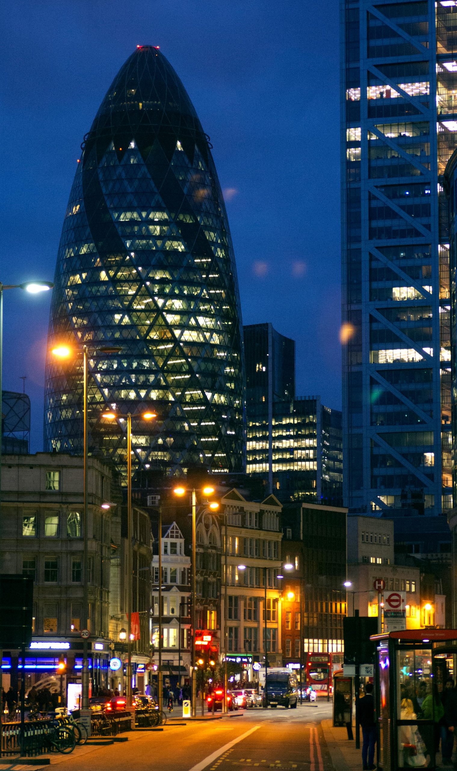 Stunning night view of London's Gherkin with illuminated city streets, capturing urban vibrancy.